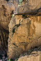 On the Caminito del Rey. Hikers and tourists walk on the footbridge that overlooks the vertiginous and narrow canyon of the Gaitanes gorges
