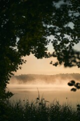Sunset with mist on the Kashubian lake. Villages in Poland. Outdoors adventures during summer.