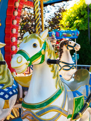Old carousel in a holiday park. Merry-go-round with horses.