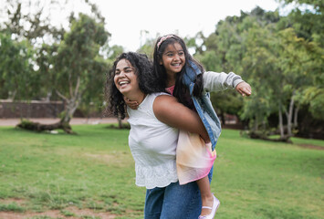 Indian mother and cute daughter having playful time at city park - Mother and child love