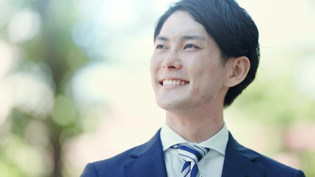 空を見上げるビジネスマンの立ち姿
