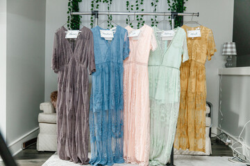 Beautiful bridesmaid dresses hanging on hangers waiting on wedding ceremony with names cards on it...