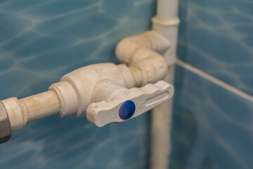 faucet on a dirty white plastic pipe with the inscription off and on