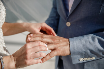 Obraz premium The bride puts a ring on the grooms finger The moment of exchanging of the rings of newlyweds Horizontal frame Wedding day Ceremony Wedding hands with rings Close up
