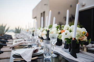 Detail of a table set for wedding banquet with floral decorations Wedding ceremony table setting for wedding Candle White flowers stylish luxury decor on wedding table Beautiful table set with candle