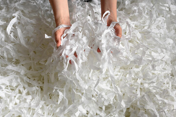 Shredded paper heap in hands. Recycle, waste, trash and ecology concept.