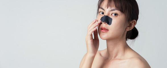 Beautiful female model with mask charcoal deep cleansing nose pore strip on fresh clean skin. - obrazy, fototapety, plakaty