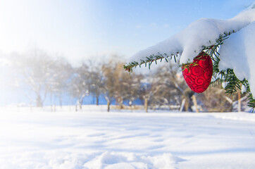 Bright decorations on a Christmas tree outdoors in the snow on a sunny day