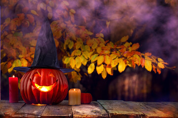 Naklejka na ściany i meble Halloween party. Carved pumpkin lantern jack among candles and night lights