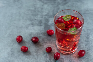 Fresh cranberries fruits juice bio organic juice health with mint on a grey slate backgroound.