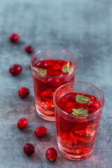 Fresh cranberries fruits juice bio organic juice health with mint on a grey slate backgroound.