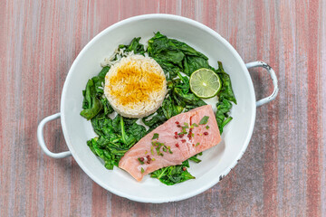 Salmon fillet with rice and spinach garnish.