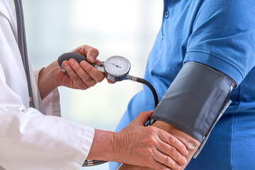 Close-up of a doctor taking blood pressure from a senior.