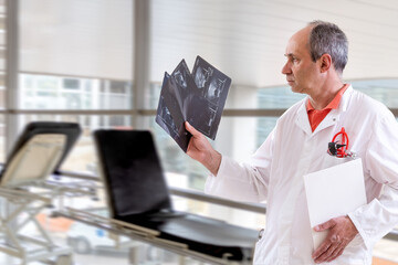 Doctor examining x-ray against blurry background.