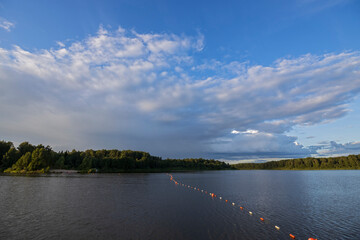 Cloudy sky over the river in the evening. Picturesque landscape with clouds and a river.