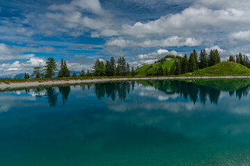Nice blue green lake on big mountains in Austria summer cloudy day