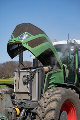 Landtechnik - Reparatur, Defekt an einem modernen Traktor auf dem Feld.