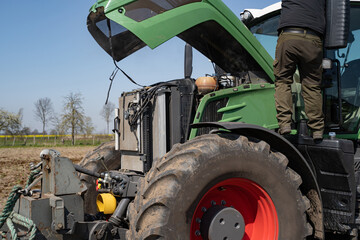 Landtechnik - Reparatur, Defekt an einem modernen Traktor auf dem Feld.