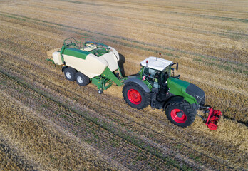 Strohernte - Stroh pressen mit einer modernen Großballenpresse, Luftbild.