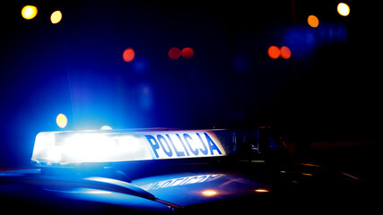 Sygnalizator błyskowy niebieski na dachu radiowozu policji polskiej w nocy.  - obrazy, fototapety, plakaty
