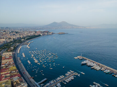 Panoramic aerial view of Naples downtown, view of the Vesuvius volcano over the city skyline facing the Mediterranean Sea, Campania, Italy.