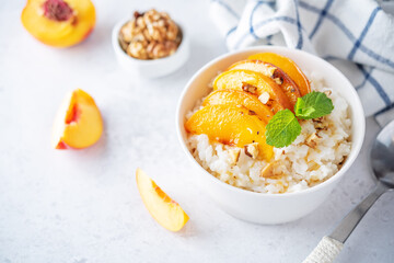 Sweet caramel rice porridge with caramelized peaches and walnuts in a bowl