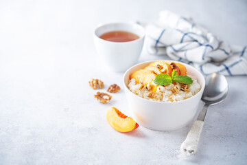 Sweet caramel rice porridge with caramelized peaches and walnuts in a bowl