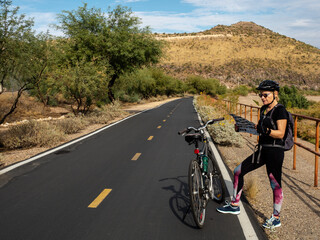 Woman locking on a map on a bicycle path in Arizona