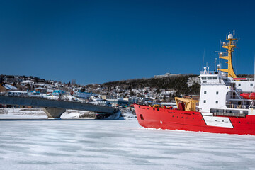 Coast Guard icebreaker at work near small coastal community in eastern Quebec, Canada.