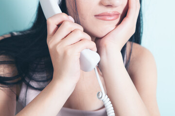 a woman dials a number on a home wired phone