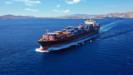 Aerial drone photo of colourful truck size container tanker ship cruising deep blue sea near...
