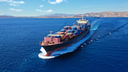 Aerial drone photo of colourful truck size container tanker ship cruising deep blue sea near...