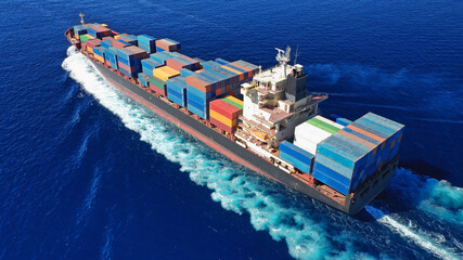 Aerial drone photo of colourful truck size container tanker ship cruising deep blue sea near...