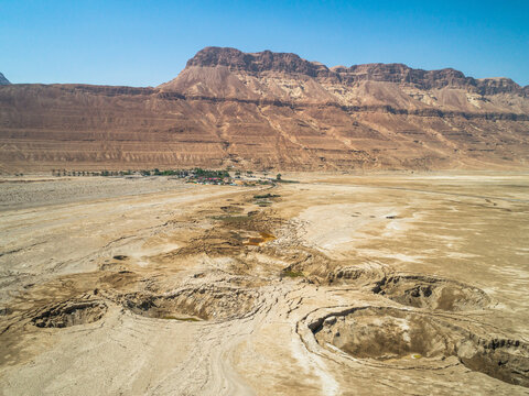 Aerial view of colourful sinkholes at and the Judaea Mountains in the background, dead-sea, Negev, Israel.