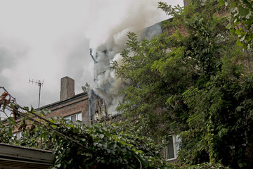 Fire in a residential five-story building. Firefighters in the basket on the fire escape assess the...