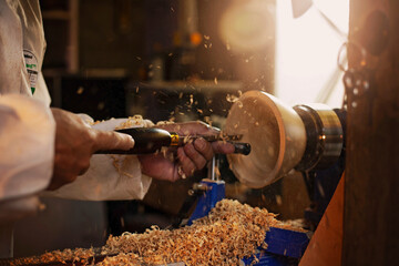 A wooden bowl being turned by a man on a woodturning lathe.A craftsman at work.Sawdust is flying.