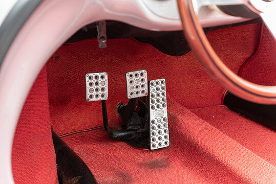 Drivers seat floor pedals control the brakes, acceleration, and clutch for the sports car of a vintage time