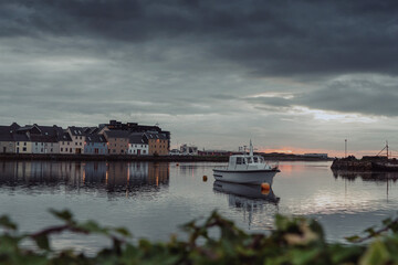 Sun rise in Galway city. High level of water in River Corrib. Dark and dramatic sky. Claddagh area and The long walk. Ireland. Popular travel and holiday destination.