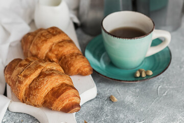 French breakfast. Freshly baked croissants and a cup of coffee on a white wooden board. Copy space. 