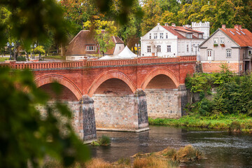 Long red brick bridge in sunny autumn morning, Kuldiga, Latvia.