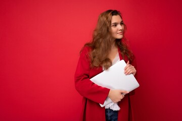 side profile photo of charming pretty young lady holding laptop isolated over wall background looking to the side and thinking over