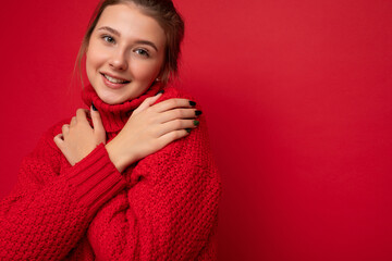 Closeup photo of young pretty brunette woman with sincere emotions isolated on background wall with copy space wearing trendy red sweater. smile and happy concept