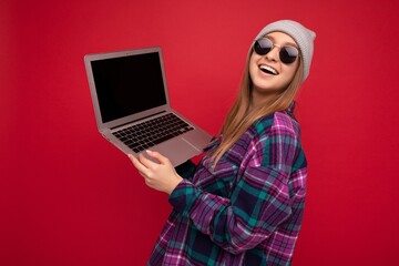 Close-up portrait of Beautiful young woman holding netbook computer looking at camera and happily laughing