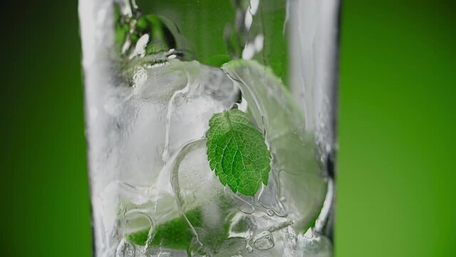 Alcohol is being poured in slow motion to the highball glass with mojito ingredients, making the alcohol drink, cocktail making isolated, Full HD Prores HQ 240 fps