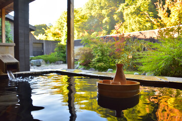 石造りの庭園露天風呂と日本酒セット - obrazy, fototapety, plakaty