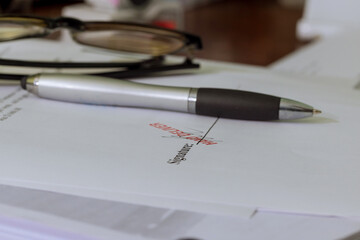 Close-up of with pen over document signature at official paper
