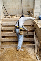 Construction worker moving dirt under newly formed steps