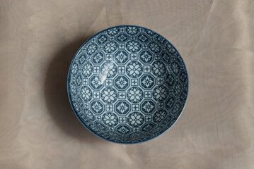 Blue ceramic bowl on pink table cloth. Ceramic tableware, Beautiful arrangement, Top view, Selective focus