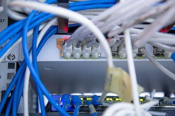 Close-up switch hub with UTP LAN network cable plugged and Lots of Ethernet cables for connect...