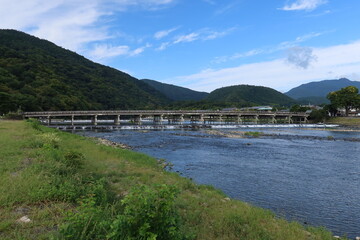 Obraz premium A tourist spot in Kyoto in Japan 日本の京都の観光地 : Katsura-gawa River and Togetsu-kyo Bridge at Arashiyama 嵐山にある渡月橋と桂川